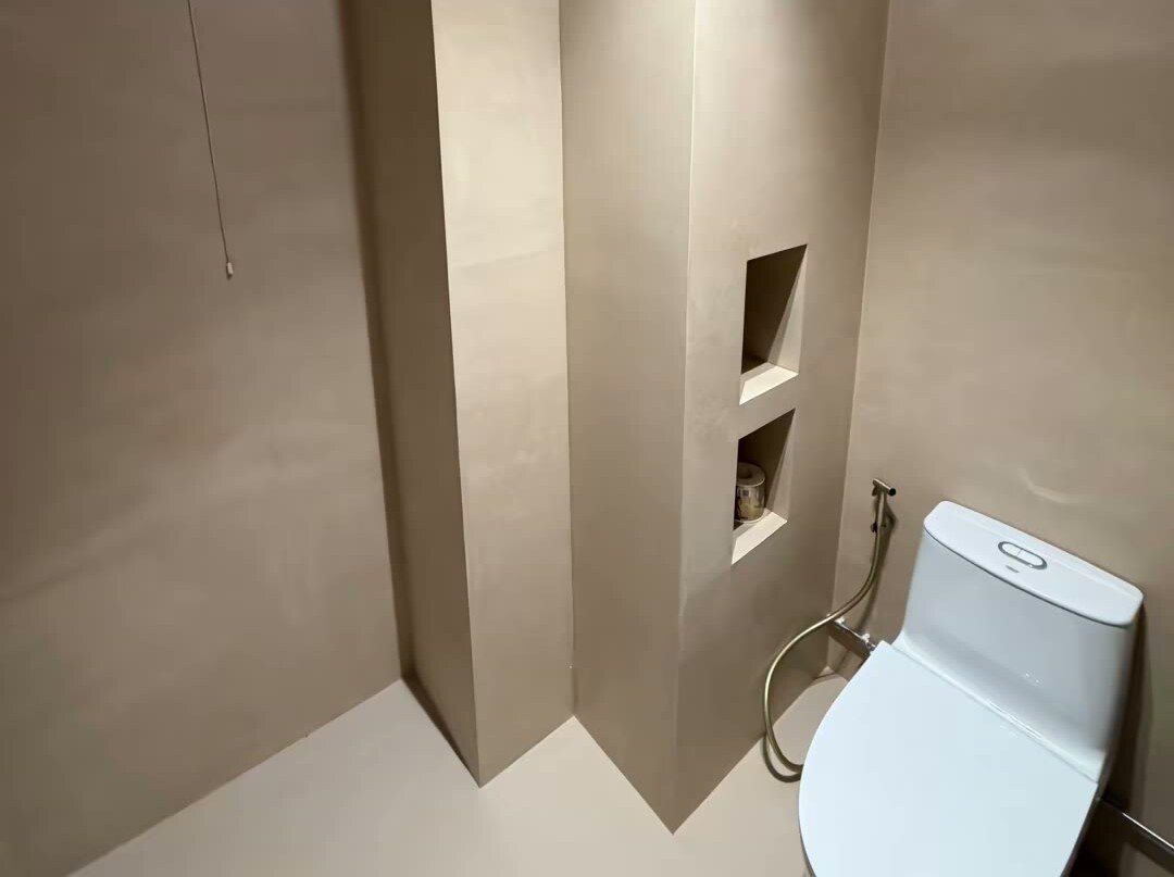 Microcement bathroom walls with niches and a wall-hung toilet