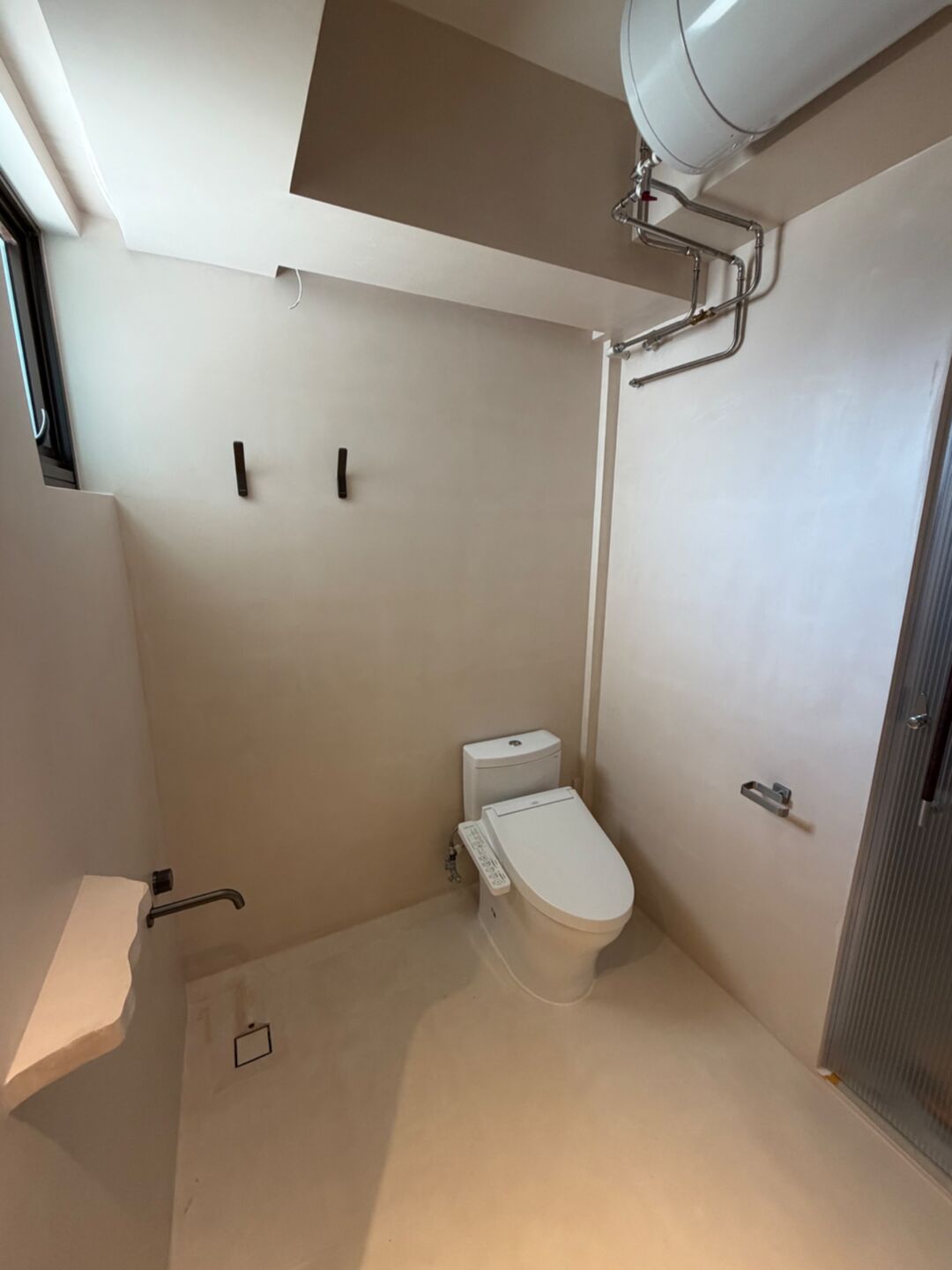 Microcement bathroom with wall-hung toilet and shower area